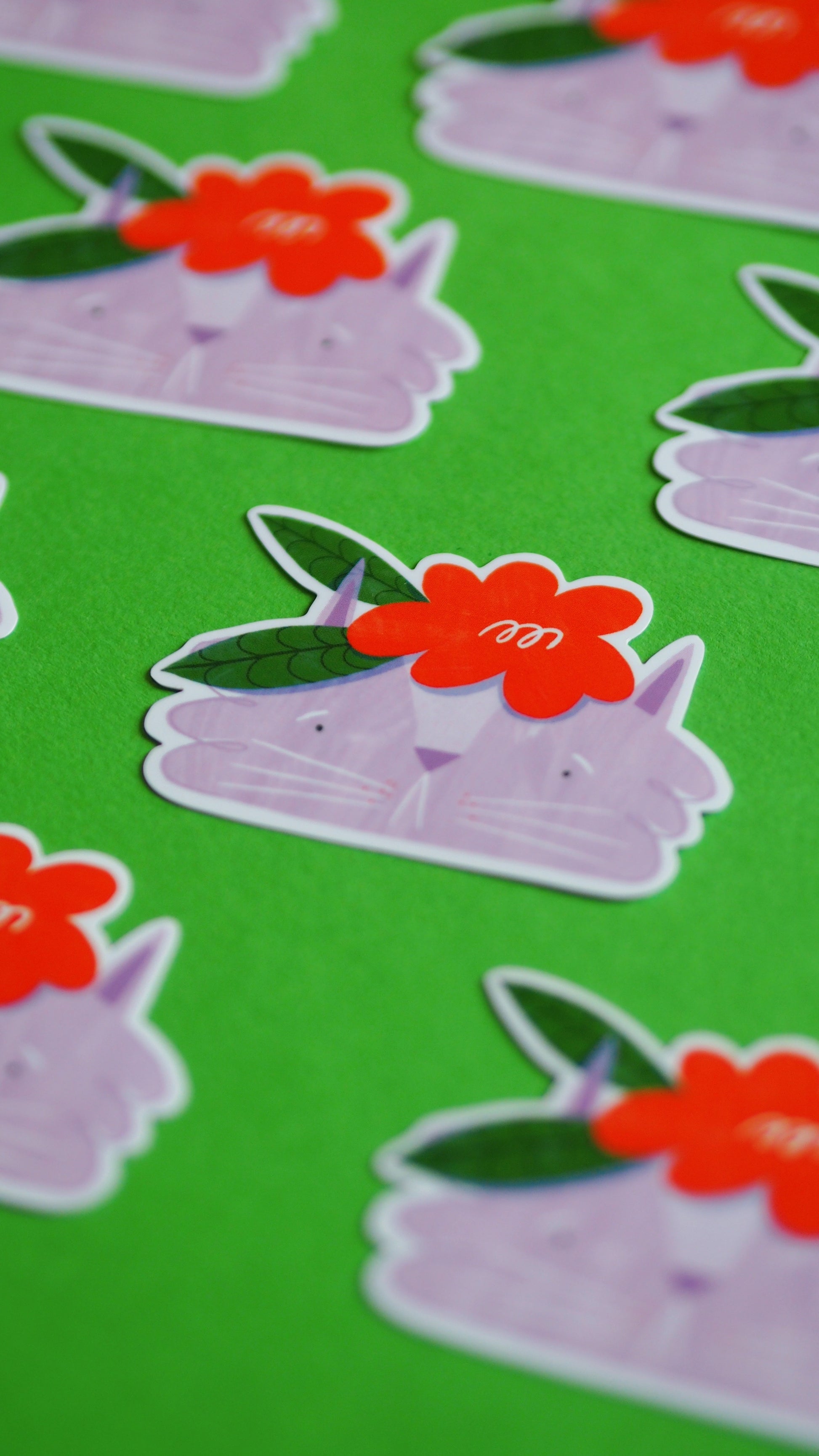 Lilac cat vinyl sticker with big red flower on head with two green leaves coming out of the side