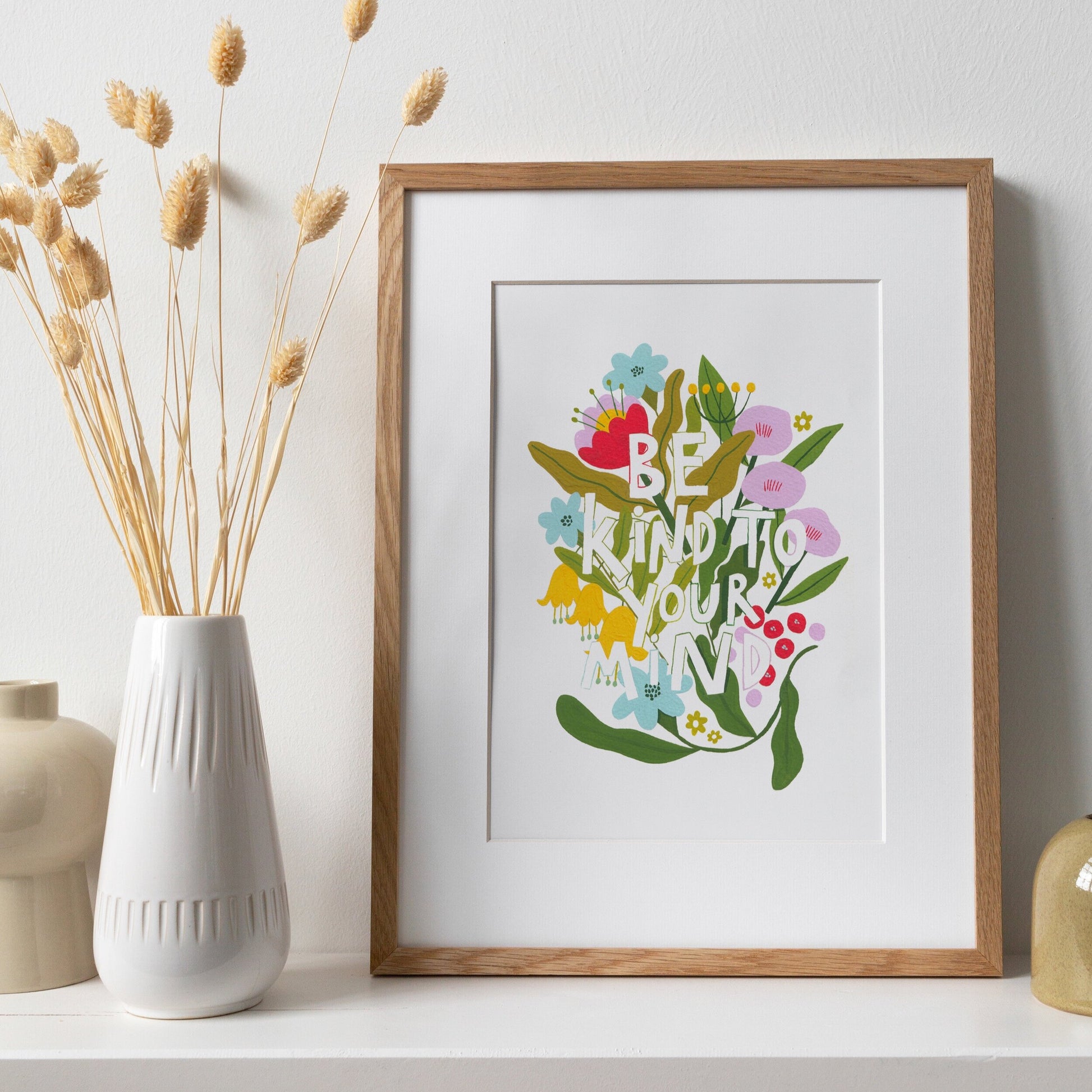 typography based print that says 'be kind to your mind' surrounded by flowers. background is white and the florals are lilac, yellow, blue and red!