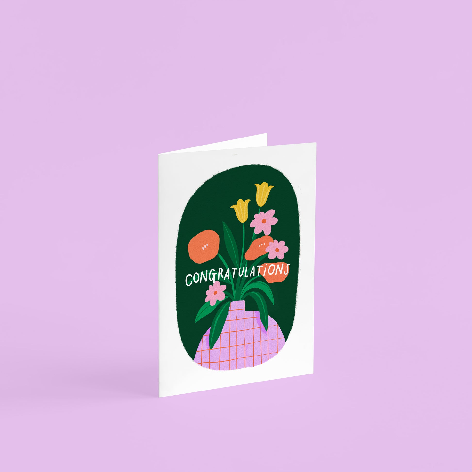 A6 greetings card with pink vase in a green oval border. the flowers are orange, yellow and pink and the text says 'congratulations' in white. 
