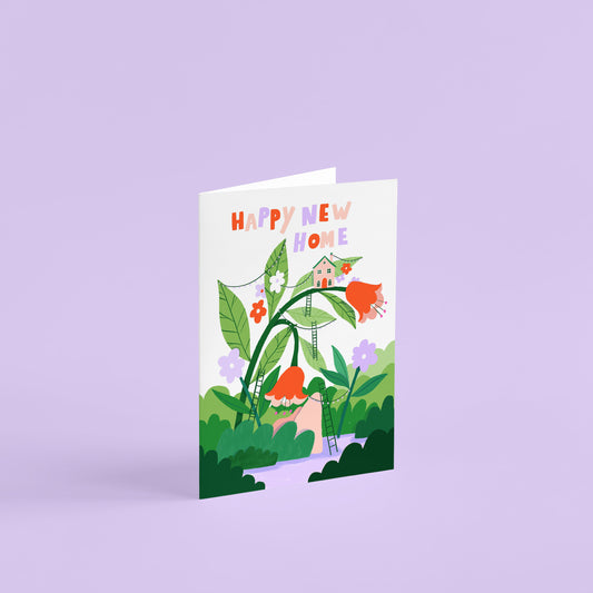 'happy new home' A6 greetings card. Tiny houses built on giant leaves of flowers. The flowers are red and lilac and there is lots of greenery and ladders leading up to the houses.