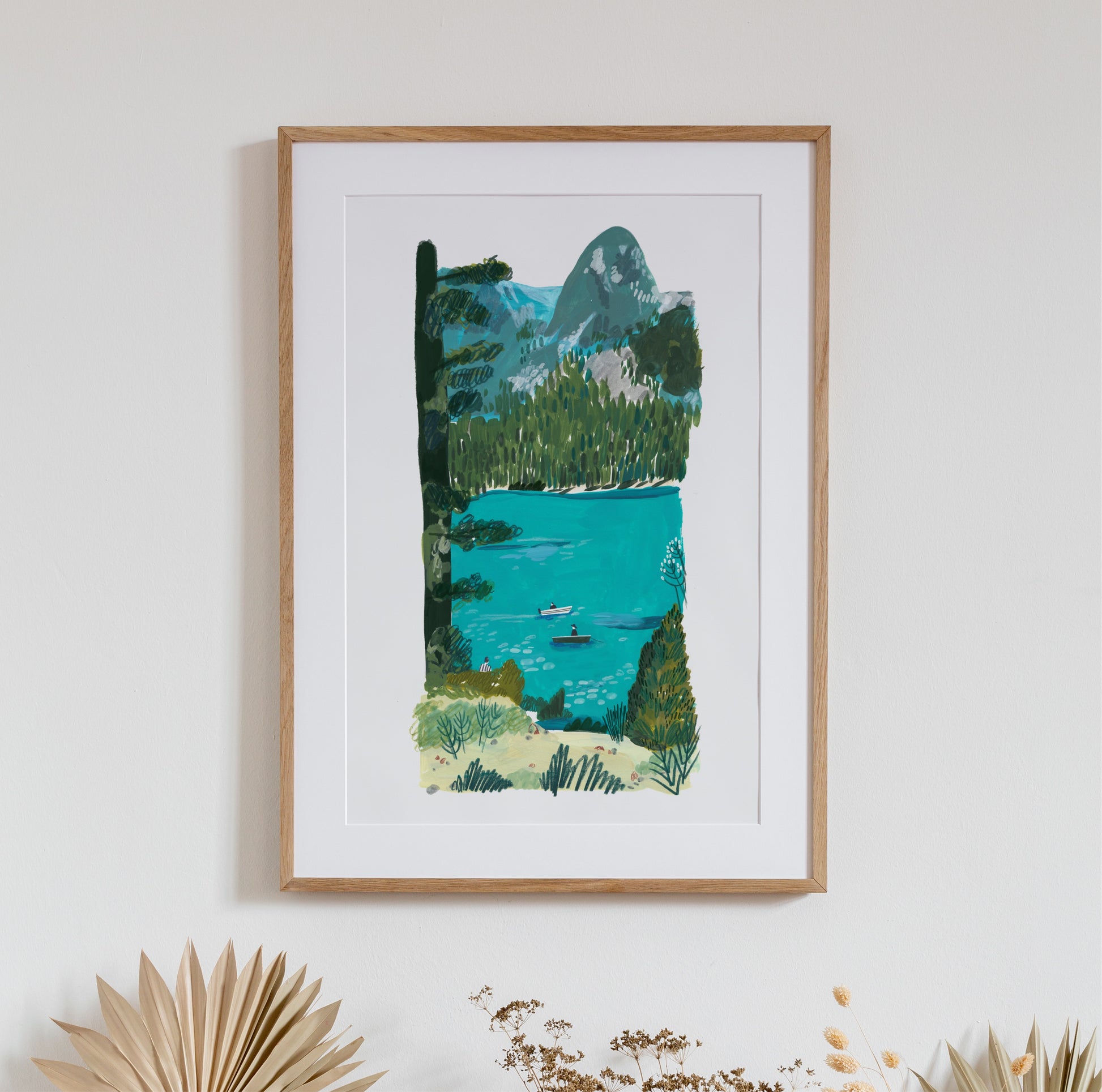 print of an original painting of lake Banff in Canada. large area of water with two small boars in it and trees and mountains in the backgraound. colours are teal, light yellow and green