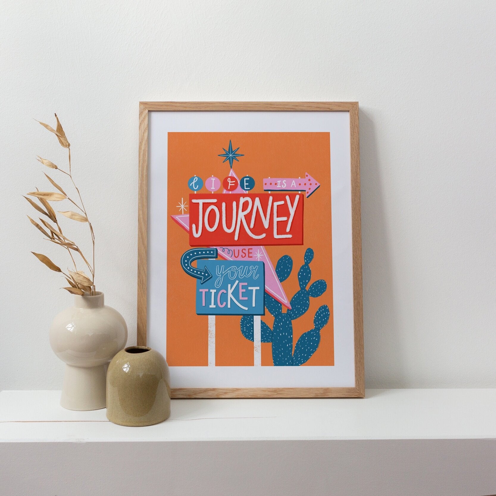 retro motel sign art print, lettering within the signs says 'life is a journey, use your ticket'. The background is orange and the colours in the signs is red, pink and blue