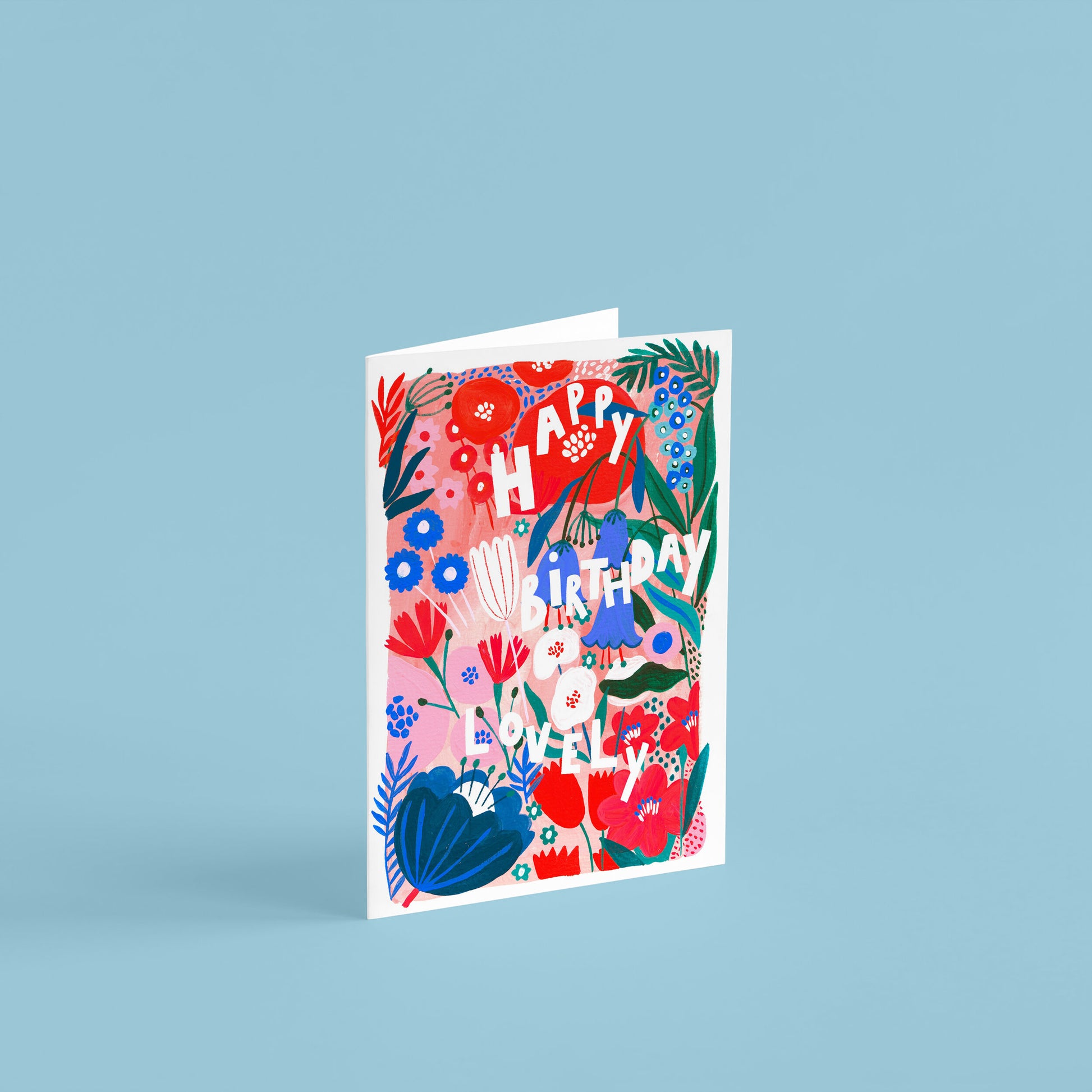 'happy birthday lovely' A6 birthday card. full floral background of red, pink and blue flowers.